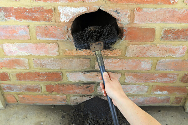 Sweeping Chimney With A Brush To Clean Out Soot